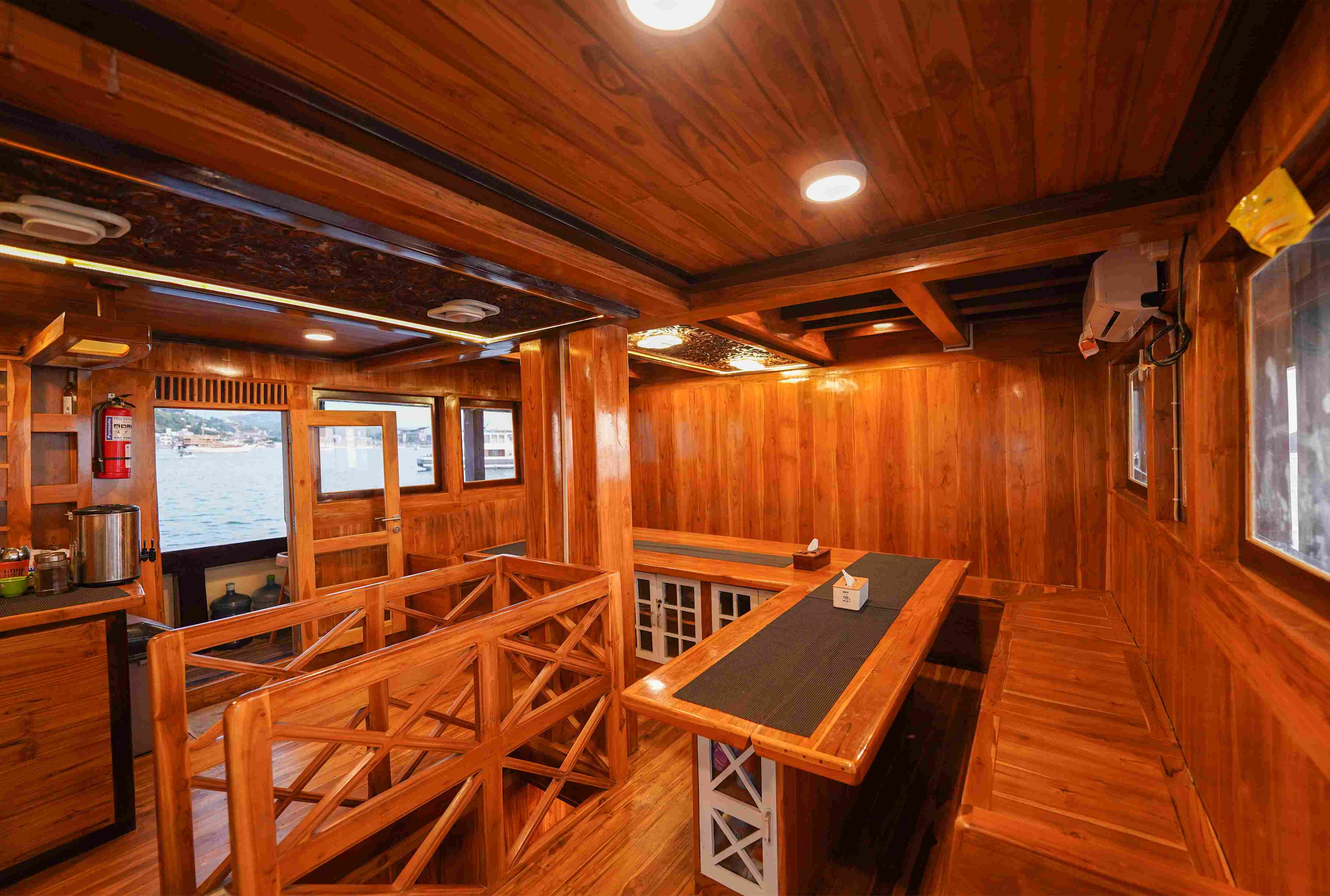 Cozy, wood-paneled indoor dining room with panoramic ocean windows.