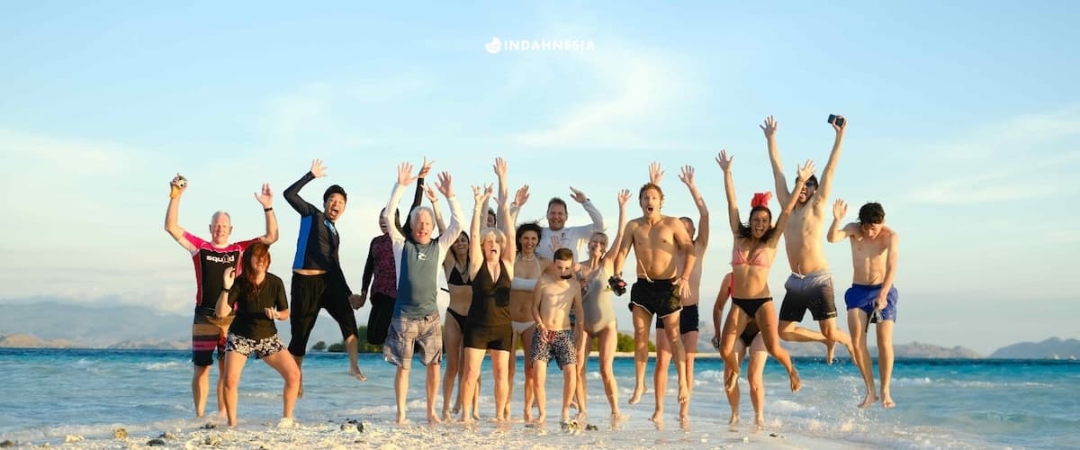 Family jumping on a sandy beach in Labuan Bajo, Flores